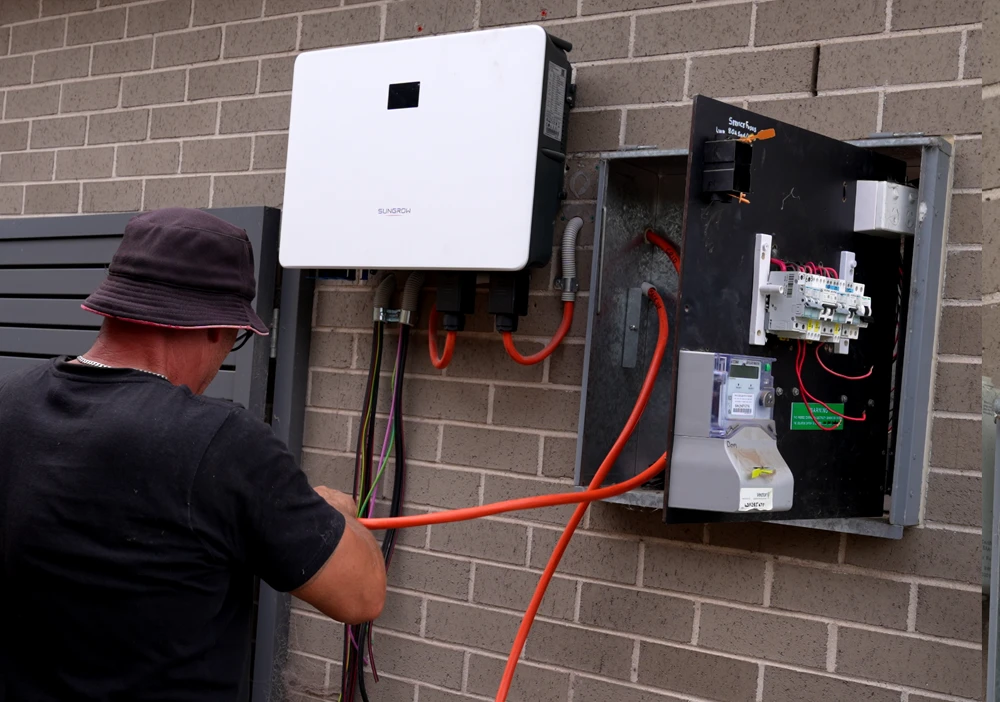 sungrow-inverter-switchboard solar installer working on switchboard and sungrow inverter